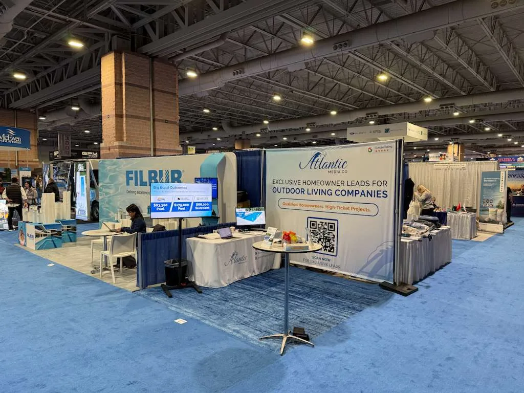 Atlantic Media Company's trade-show booth with its branded pull-up banner and display table on the show floor